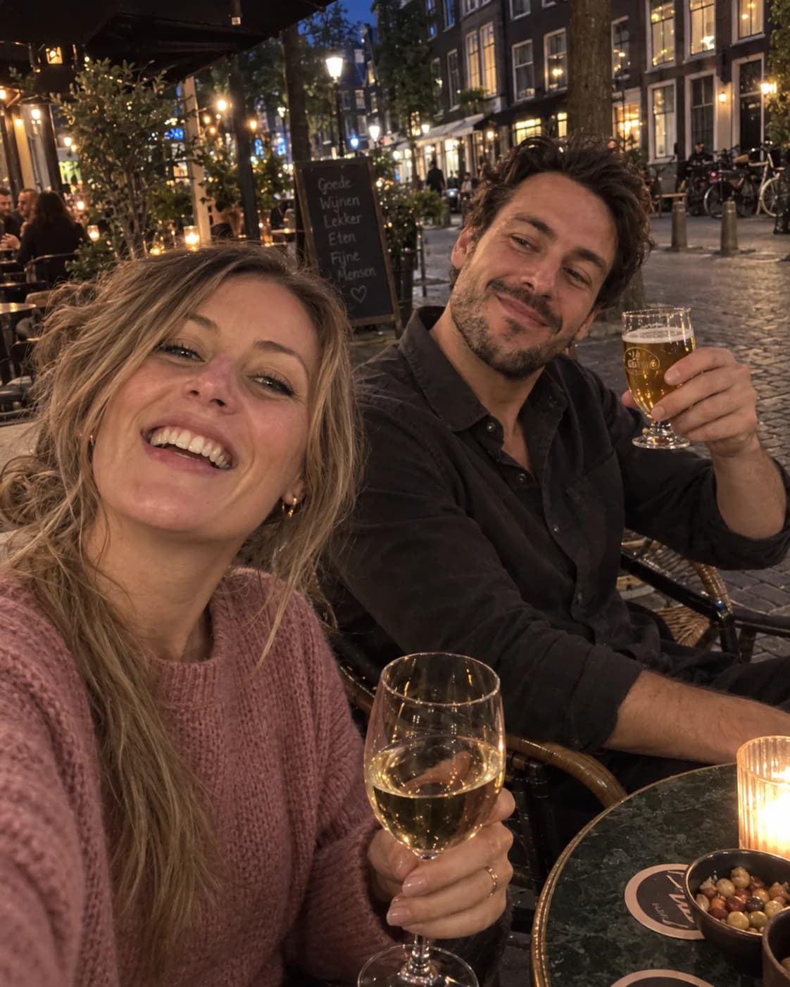 Sophie maakt een selfie op het terras terwijl Daan zijn glas heft